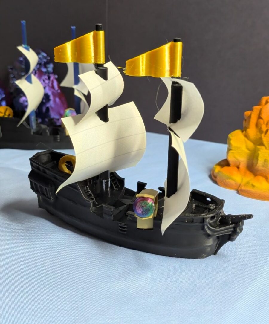 Queen's Fleet ship with paper sails and gold-tipped flags.